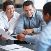 A photo of a couple reviewing paperwork with a professional.